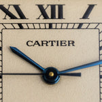 Détail de la signature Cartier et des aiguilles en acier bleui sur le cadran crème, montre vintage