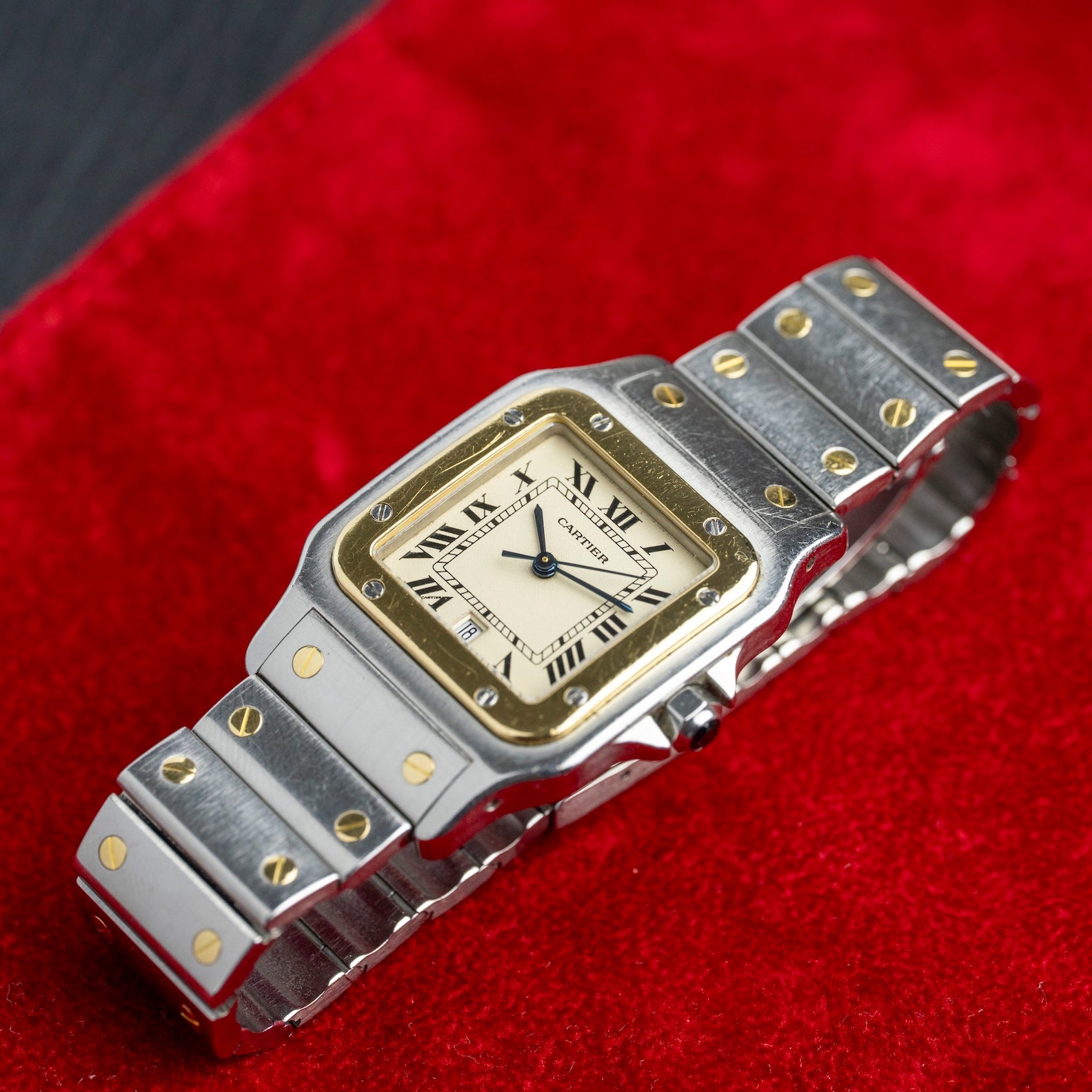 Cartier Santos Galbée 187901 posée sur velours rouge, bracelet acier et or, montre ancienne