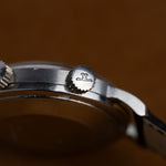 Couronne signée du logo JLC, détail du boîtier de la Jaeger-LeCoultre Memovox, montre ancienne