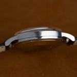 Profil gauche du boîtier acier de la Jaeger-LeCoultre Memovox E855, montre vintage