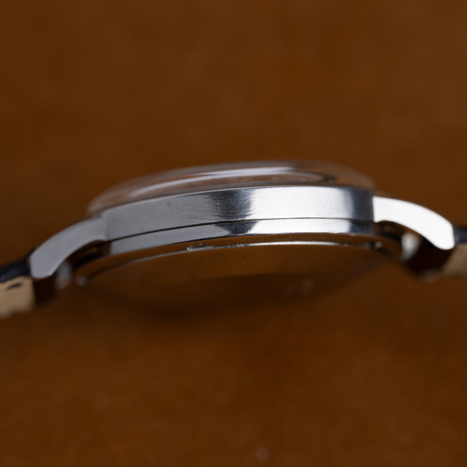 Profil gauche du boîtier acier de la Jaeger-LeCoultre Memovox E855, montre vintage