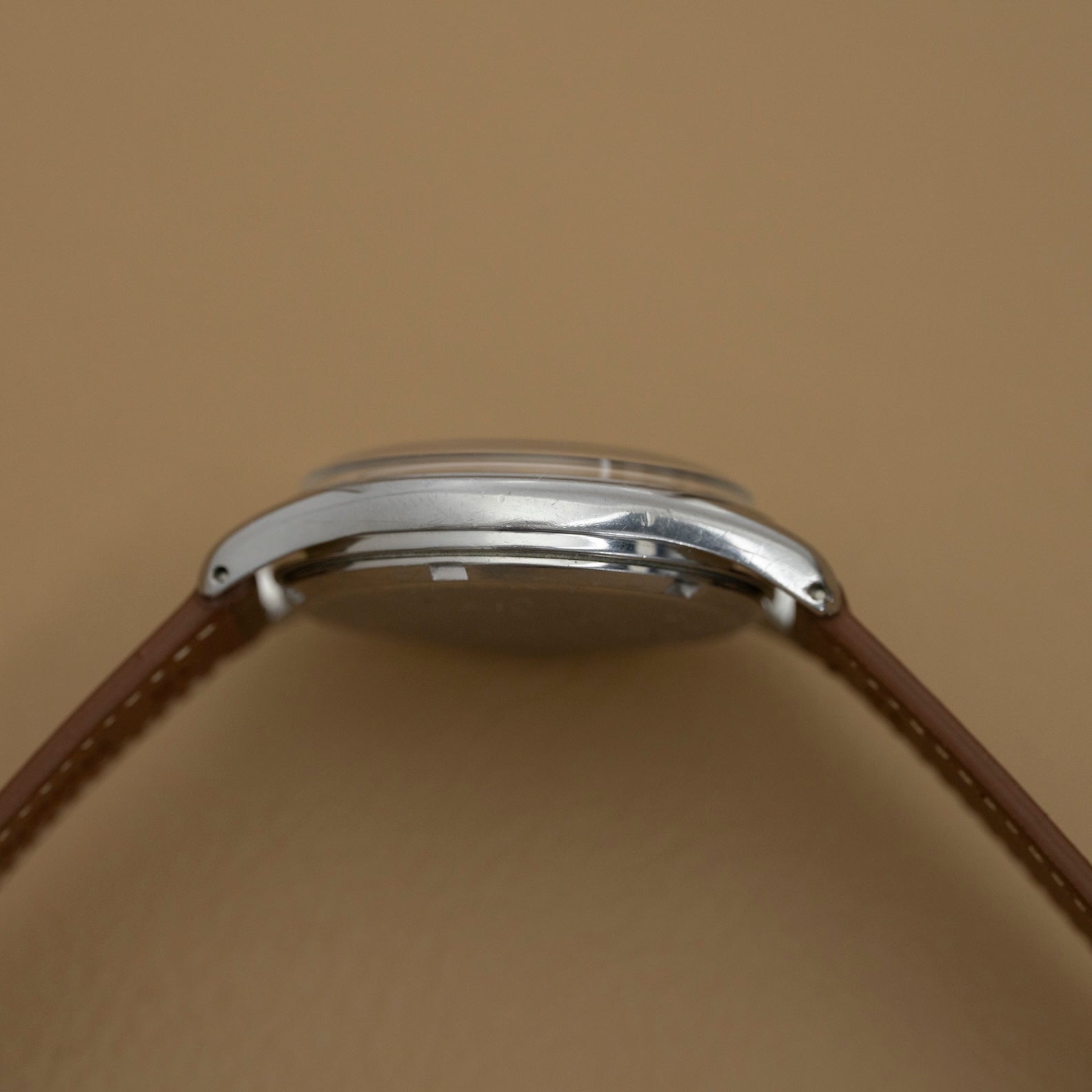 Profil gauche du boîtier acier de l'Omega Jumbo cadran chocolat, montre ancienne