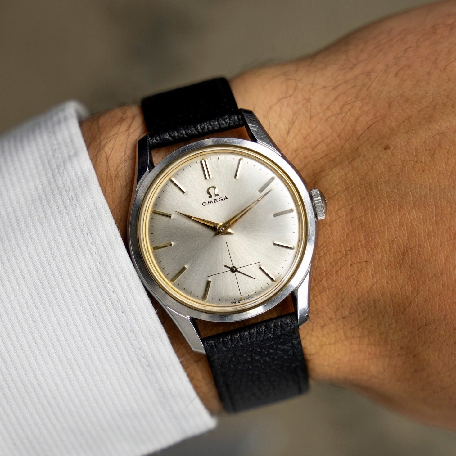 Montre vintage Omega Jumbo 2639-12 de 1952 au poignet, cadran argenté soleillé et bracelet cuir noir