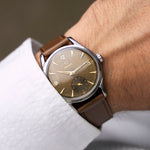 Montre vintage Omega Jumbo 2639-12 de 1952 au poignet, cadran chocolat patiné et bracelet cuir marron