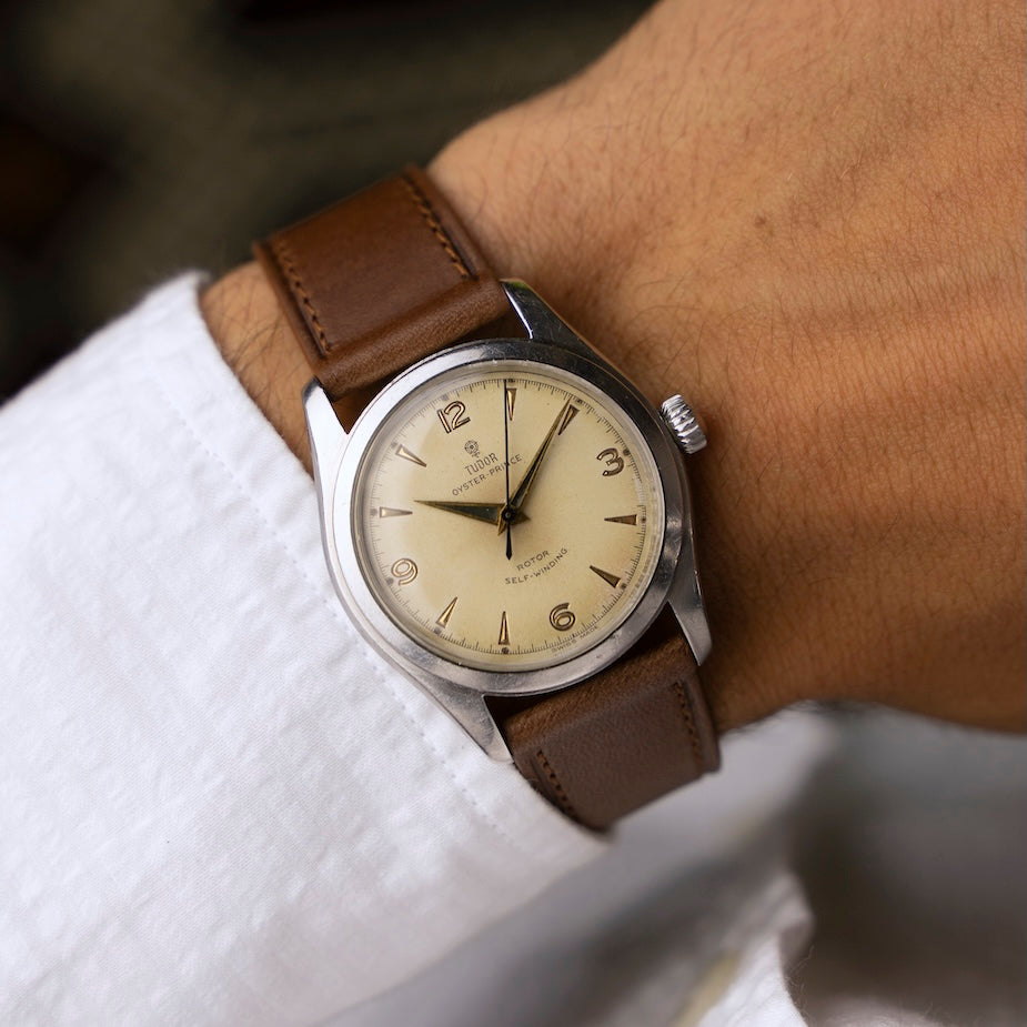 Montre vintage Tudor Oyster Prince 7808 des années 1950 au poignet, cadran crème et bracelet cuir camel