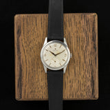 Vintage Zenith Pilot front view, resting on a wooden stand
