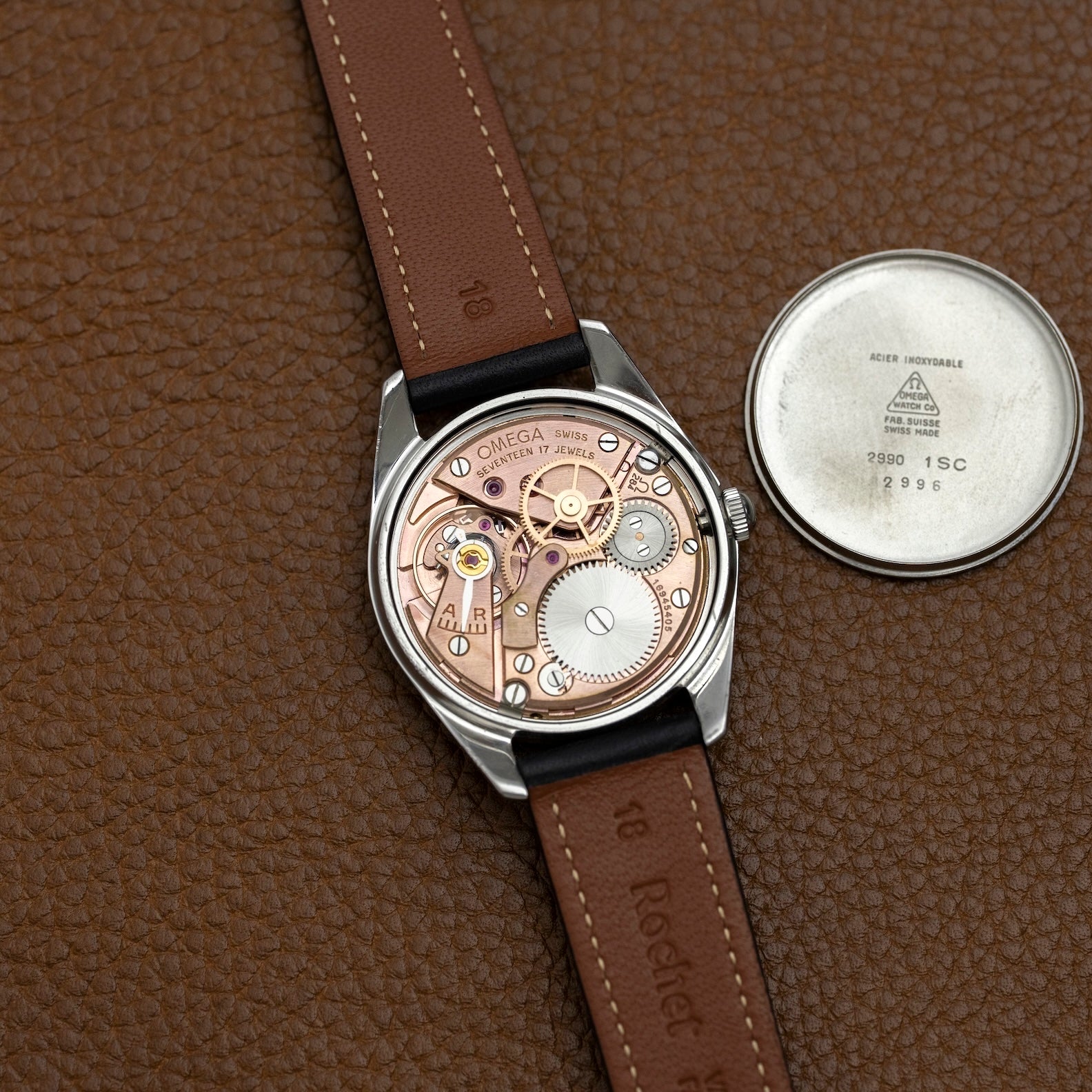 Omega Ranchero ouverte sur bracelet cuir marron, fond de boîte à côté, montre vintage